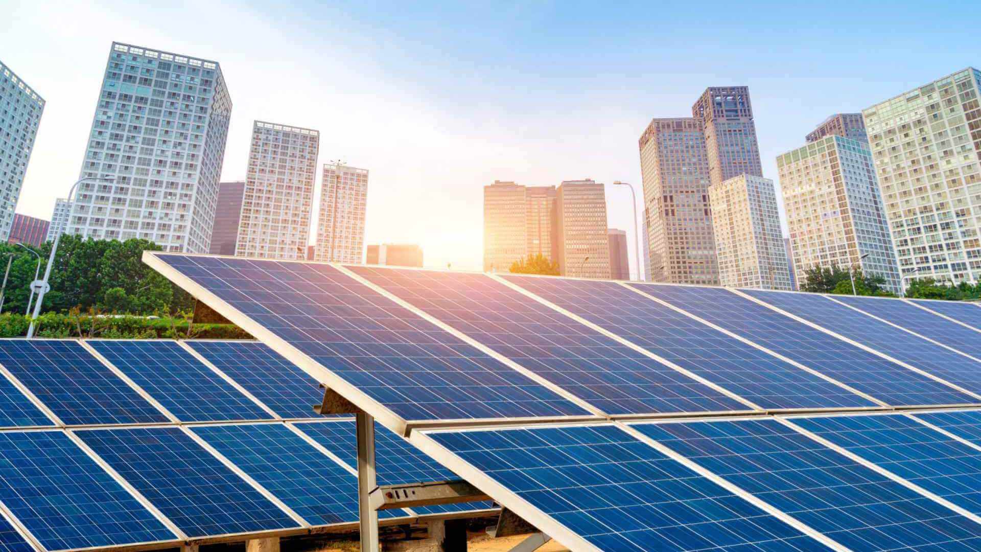 Solar array in front of a city skyline at sunrise