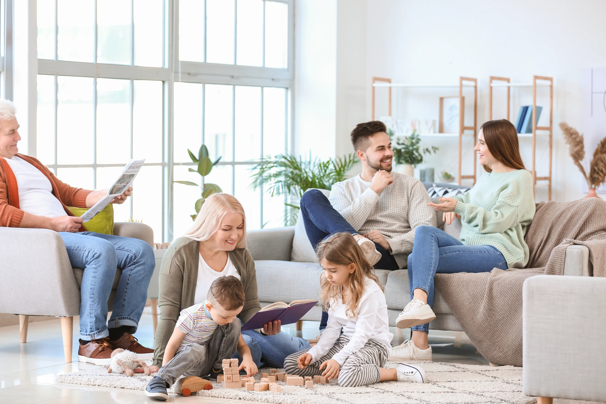 Family of three generations relaxing together in a bright, comfortable living room