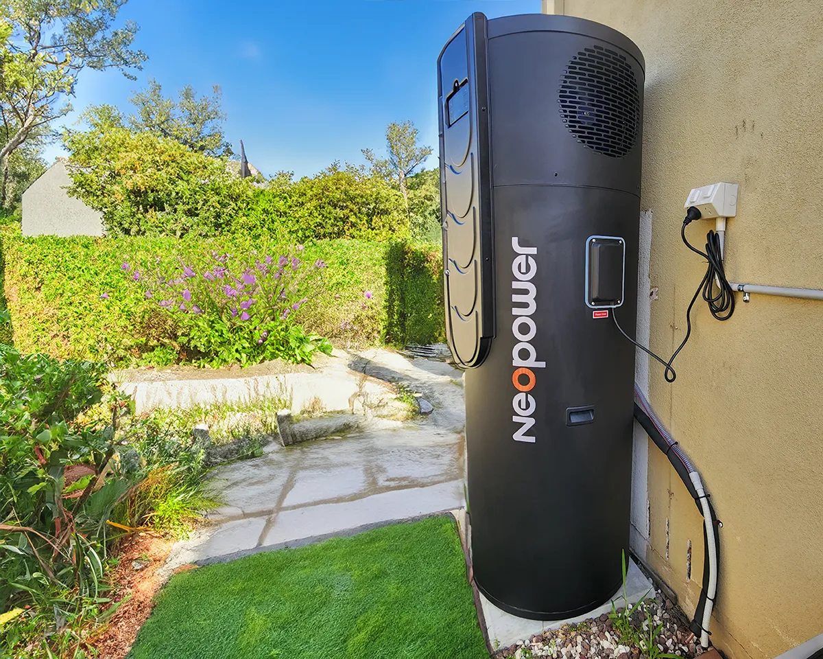 NeoPower heat pump hot water system installed outside a home beside a garden